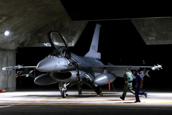 Seorang pilot dan prajurit Angkatan Udara berlari menuju jet tempur F-16V untuk lepas landas sore hari sebagai bagian dari misi kesiapan tempur di pangkalan udara Hualien, Taiwan, 17 Agustus 2022. REUTERS 