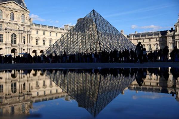Orang-orang berdiri di luar Museum Louvre, setelah polisi Prancis menangkap tersangka dalam kasus perampokan Louvre, di Paris, Prancis, 26 Oktober 2025. REUTERS 
