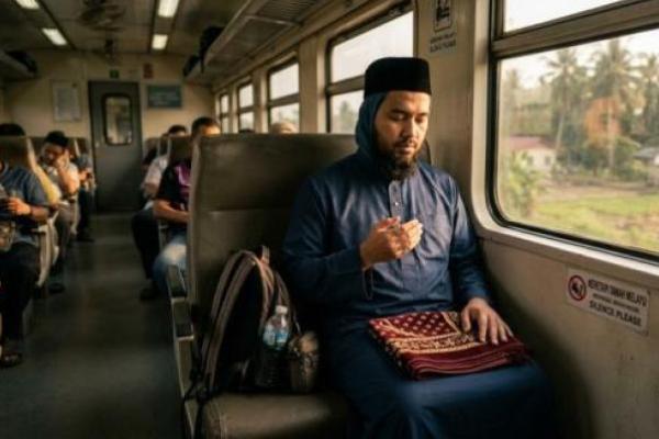 Ilustrasi - sholat di kereta ketika safar (Foto: AI) 