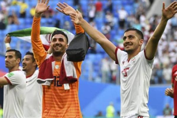 Kiper Iran Rashid Mazaheri dan bek Iran Majid Hosseini merayakan setelah peluit akhir pertandingan sepak bola Grup B Piala Dunia Rusia 2018 antara Maroko dan Iran di Stadion Saint Petersburg di Saint Petersburg pada 15 Juni 2018. (Foto: AFP) 