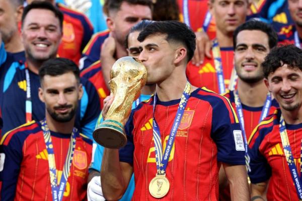 Gelandang timnas Spanyol, Pedri mencium trofi Piala Dunia (Foto: FIFA)