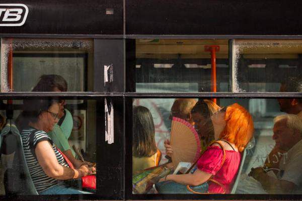 Seorang wanita menggunakan kipas angin untuk mendinginkan diri saat naik bus di hari yang panas, ketika Badan Prakiraan Cuaca Nasional mengeluarkan peringatan kode merah panas ekstrem untuk sebagian besar wilayah negara itu, di Bukares, Rumania. (AP) 