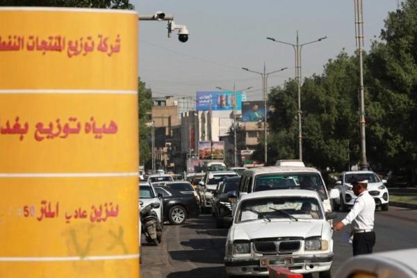 Seorang petugas polisi lalu lintas Irak mengatur antrean di sebuah SPBU di ibu kota Irak, Baghdad. (Foto: AFP) 