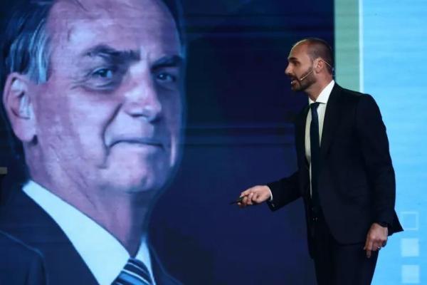 Eduardo Bolsonaro berbicara di samping gambar ayahnya, mantan Presiden Brasil Jair Bolsonaro (Foto: Tomas Cuesta/Getty Images) 