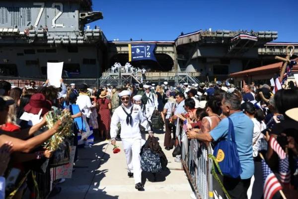 Para pelaut turun dari kapal induk USS Abraham Lincoln di Pangkalan Udara Angkatan Laut North Island di San Diego, California, pada 8 Oktober 2026 (Foto: David Swanson/AFP) 