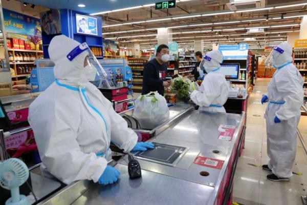 Pelayan di pusat perbelanjaan Shanghai mengenakan hazmat saat melayani pembeli. Foto: Reuters 