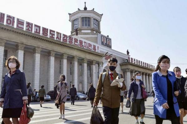 Orang-orang yang memakai masker pelindung berjalan di tengah kekhawatiran atas penyakit virus corona baru di Pyongyang, Korea Utara. Foto: Reuters 