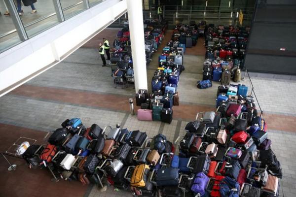 Petugas mengawasi bagasi penumpang di Terminal 2 di Bandara Heathrow London, Inggris, 19 Juni 2022. Foto: Reuters 