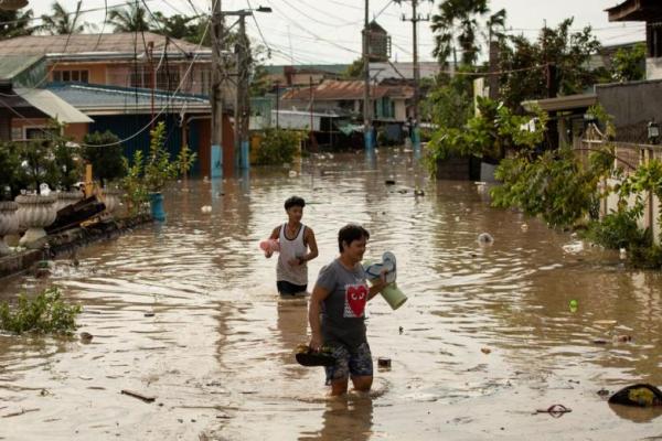 Warga mengarungi banjir setinggi pinggang setelah Topan Super Noru, di San Miguel, provinsi Bulacan, Filipina, 26 September 2022. Foto: Reuters 
