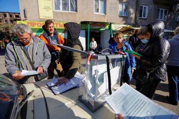 Orang-orang berkumpul di sekitar kotak suara referendum, di Mariupol, Ukraina 25 September 2022. Foto: Reuters 