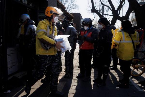 Seorang pengemudi pengiriman mengambil obat dari apotek di Beijing, 7 Desember 2022. Foto: Reuters 