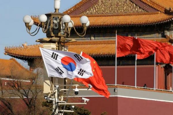 Bendera Korea Selatan dan China berkibar di samping Gerbang Tiananmen saat Presiden Korea Selatan Moon Jae-In di Beijing, 15 Desember 2017. Foto: Reuters 