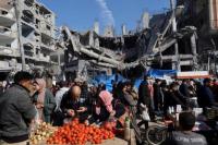 Warga Palestina berbelanja di pasar terbuka dekat reruntuhan rumah dan bangunan akibat serangan Israel, di Jalur Gaza tengah 30 November 2023. Foto: Reuters